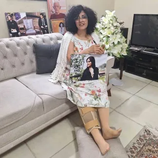  در این تصویر، او عکس مهسا امینی را در دست دارد و روی دست دیگرش نوشته شده: «نه به آپارتاید جنسیتی». 📌 اجرای حکم زندان نرگس محمدی با استناد به نظر پزشکی قانونی به مدت سه هفته متوقف شده است.