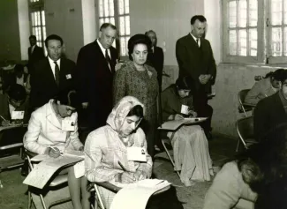  خانم فرخ رو پارسا وزیر آموزش و پرورش دولت هویدا در حال بازدید از جلسه آزمون یکی از مراکز تربیت‌ معلم در استان فارس است.