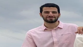  پدر سرباز وظیفه پارسا شکوهی با پیراهن سفید و نشان دادن علامت پیروزی در مراسم پسرش شرکت کرد