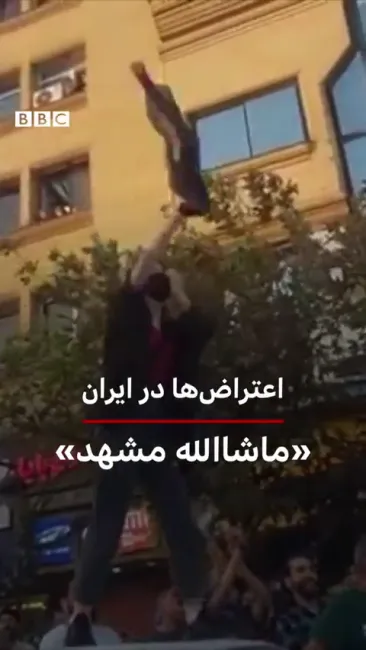  مشهد - زنی معترض به بالای خودرویی رفته و روسری‌اش را در میان تشویق معترضان در هوا تکان می‌دهد